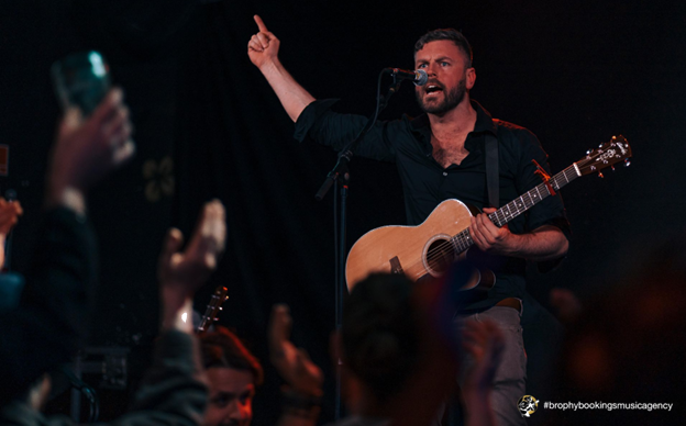 Stephen Cooper singer performing live on stage with guitar and engaging crowd